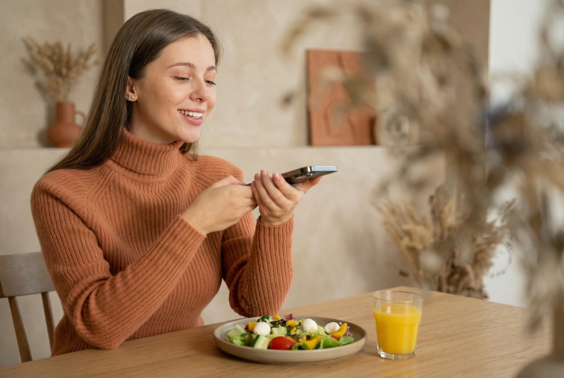 Female using smartphone while eating healthy organic grilled chicken salad